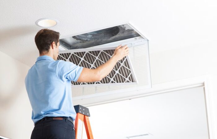 Close-up of a dusty AC vent indicating clogged air ducts